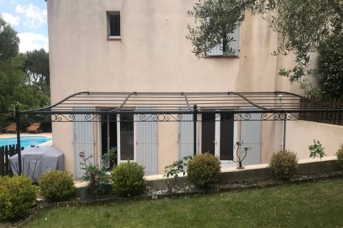 Pergola sur mesure fer forgé décor poutre volutes avec poteaux sur muret installée à Gréasque